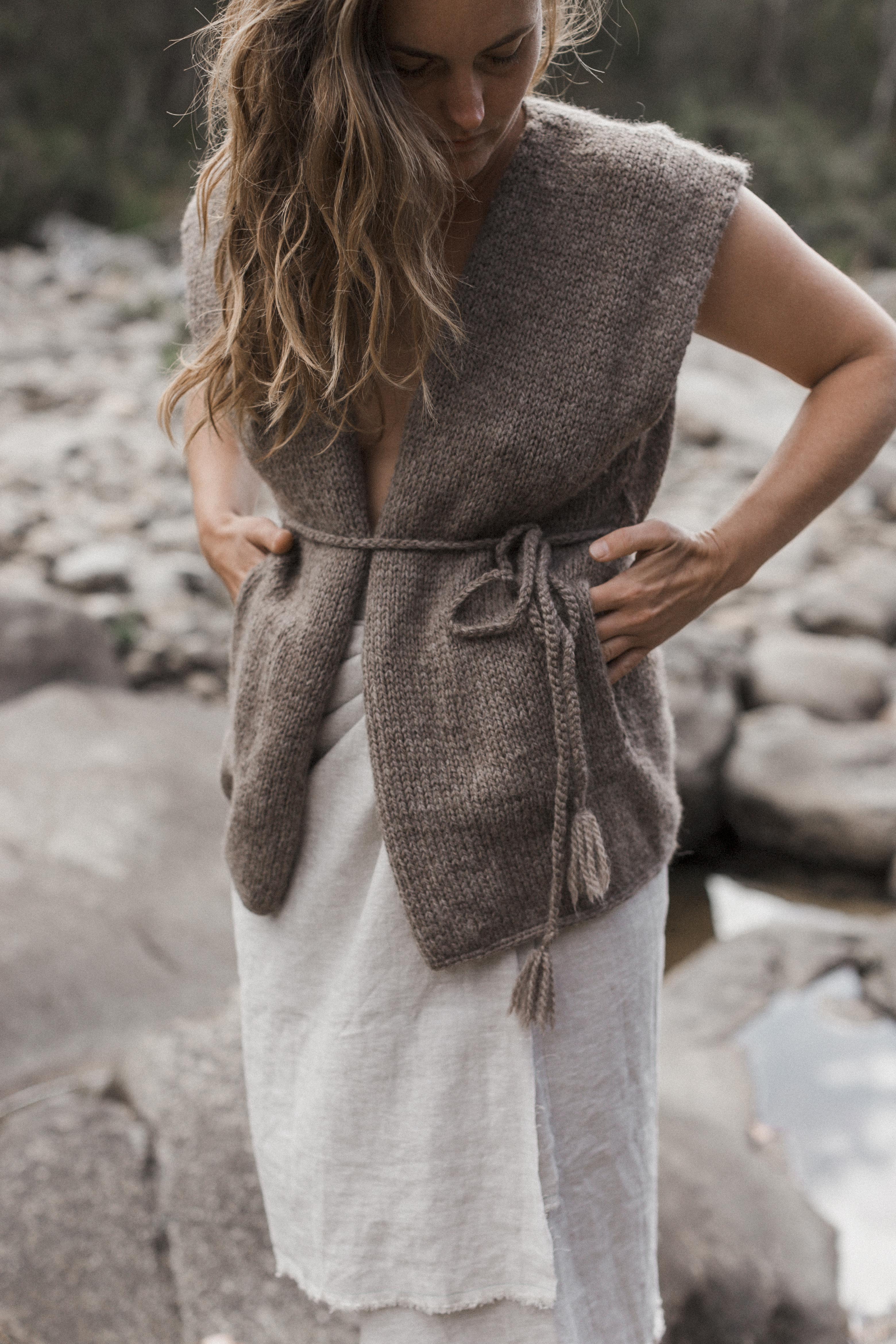 A hand-knitted woolen vest in brown colour with a tie